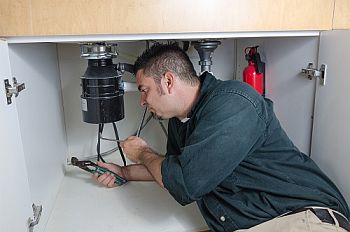 Louis is working on a garbage disposal repair